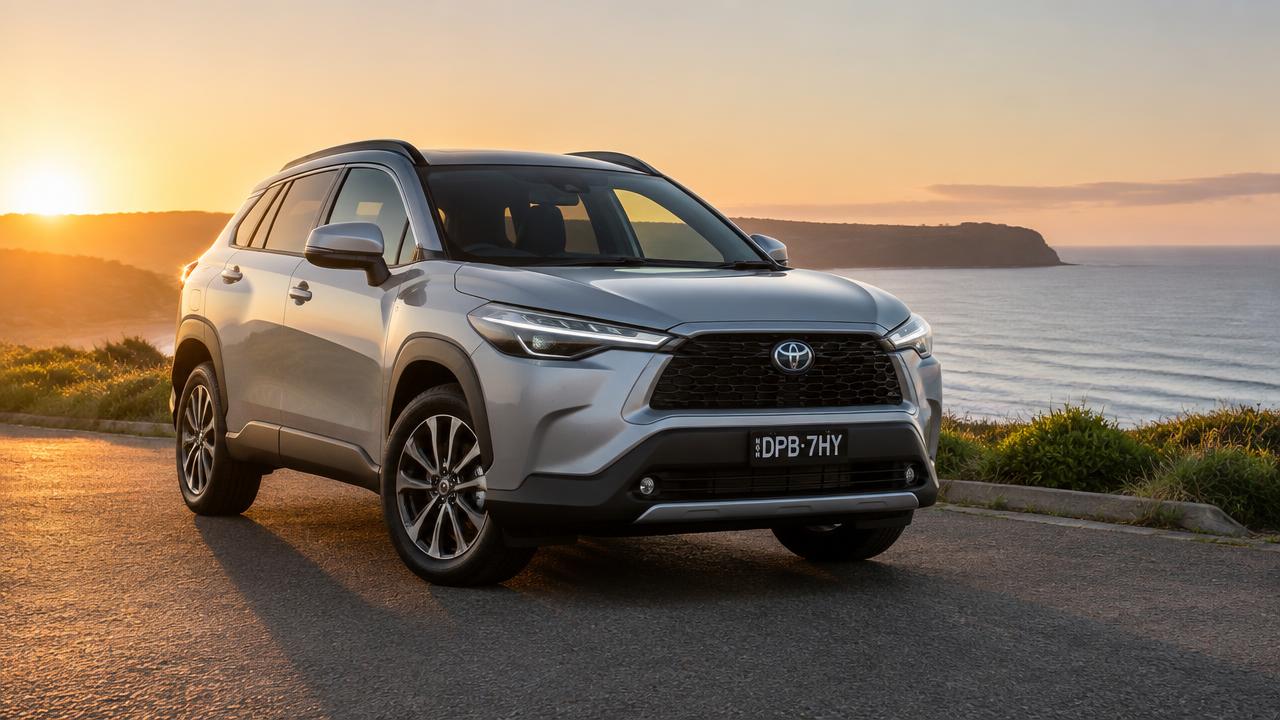 A silver SUV parked on a coastal road at sunset